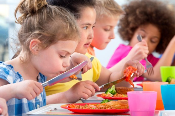 Niños y niñas comiendo.